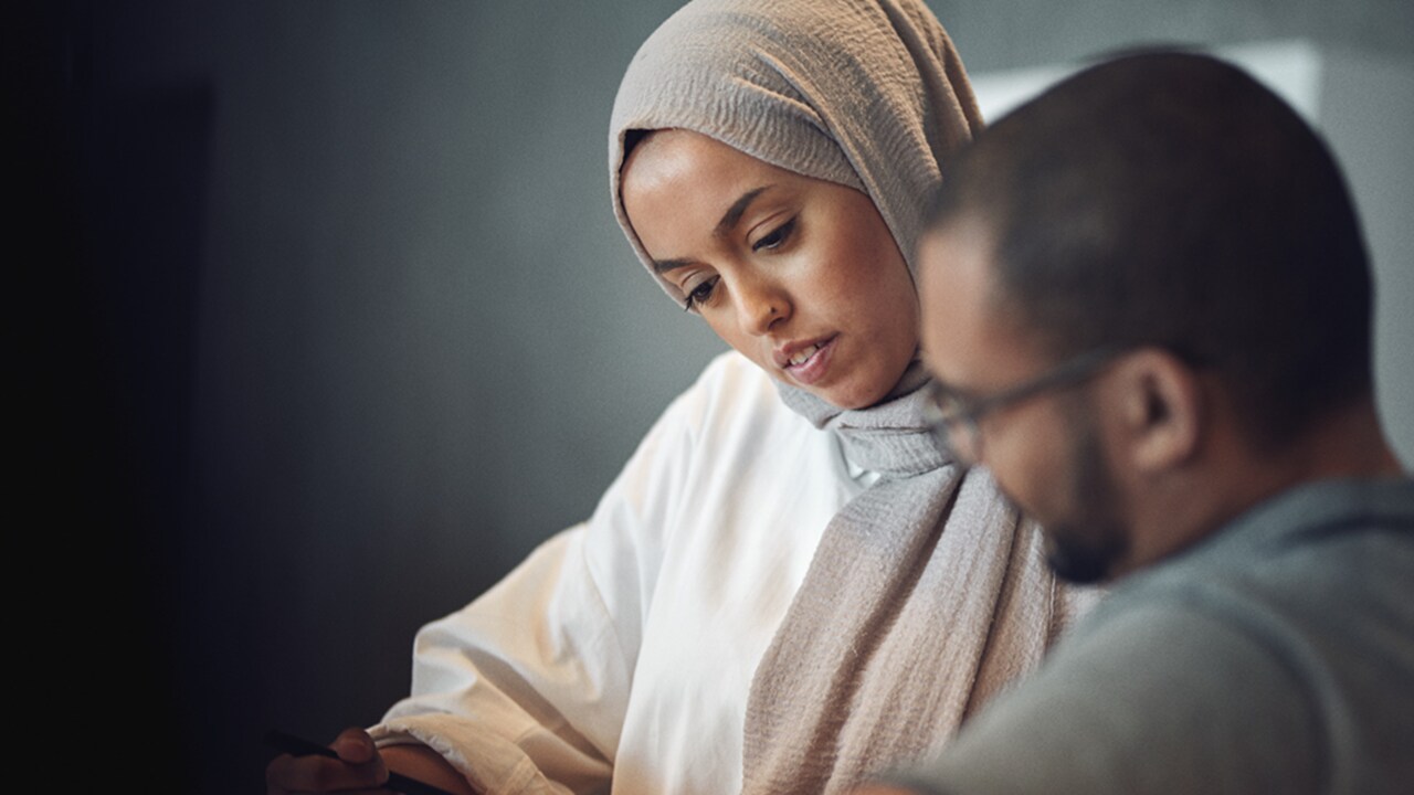 Female and male employee are discussing work.