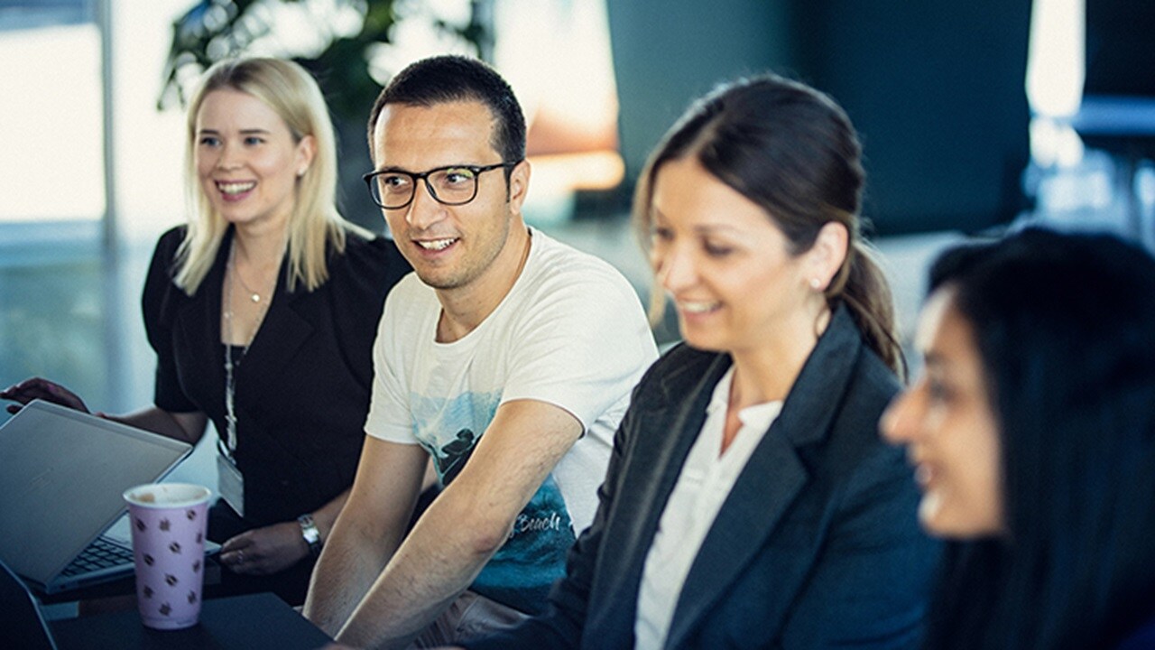 东升国际办公室里一群面带微笑的员工。