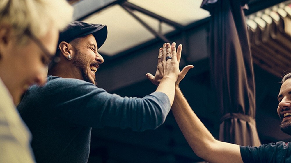 The employee enthusiastically celebrates success with a high-five gesture.