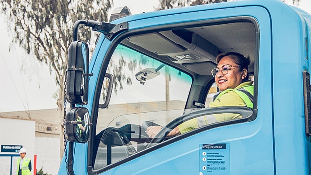 Truck driver seated inside a Maersk vehicle, viewed through the open driver-side window