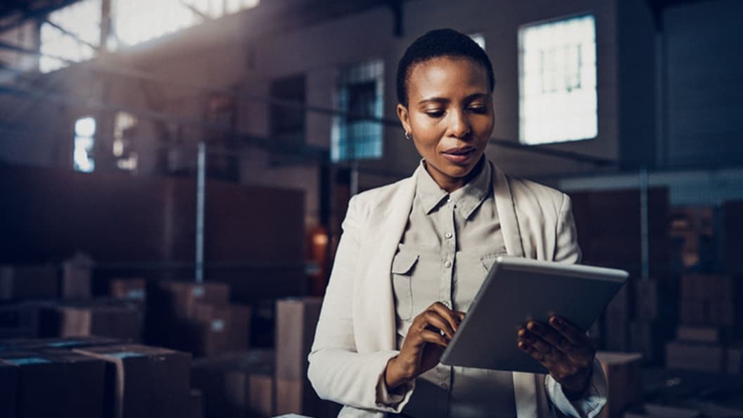 A black woman is standing in a warehouse