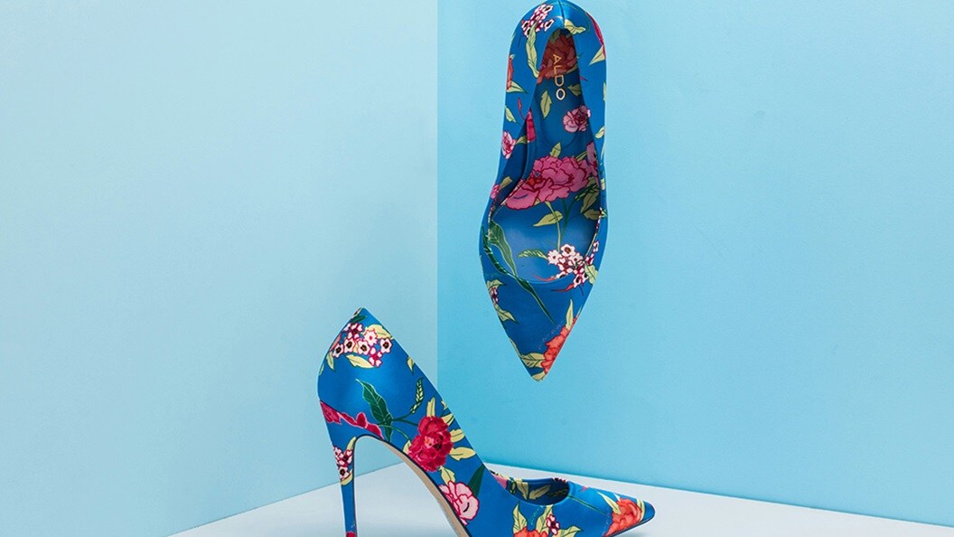 Flowered blue shoes displayed on a stand