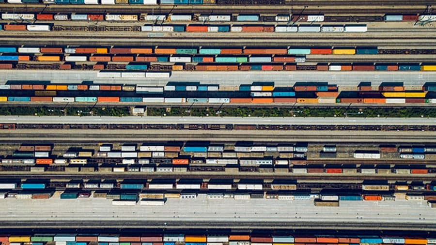 A train yard with many containers on parked trains