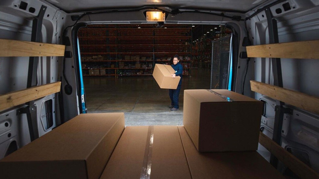 A working woman moving a less than container load box to a truck.