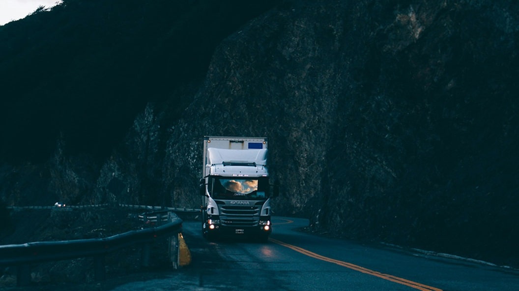 Trailer truck passing on road near rail guard