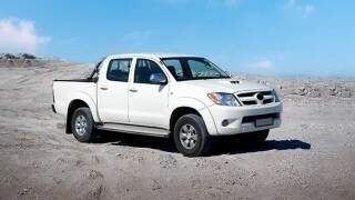 Photo of a white car on a barren land