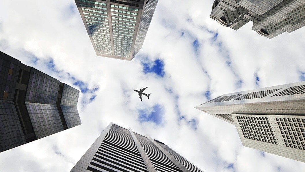 Airplane flying high in the sky with clouds in the background