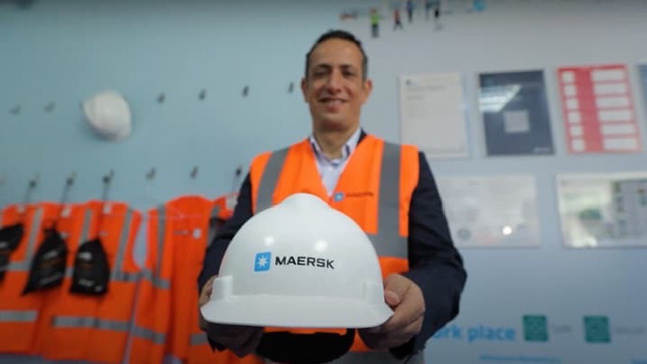 man holding maersk hat