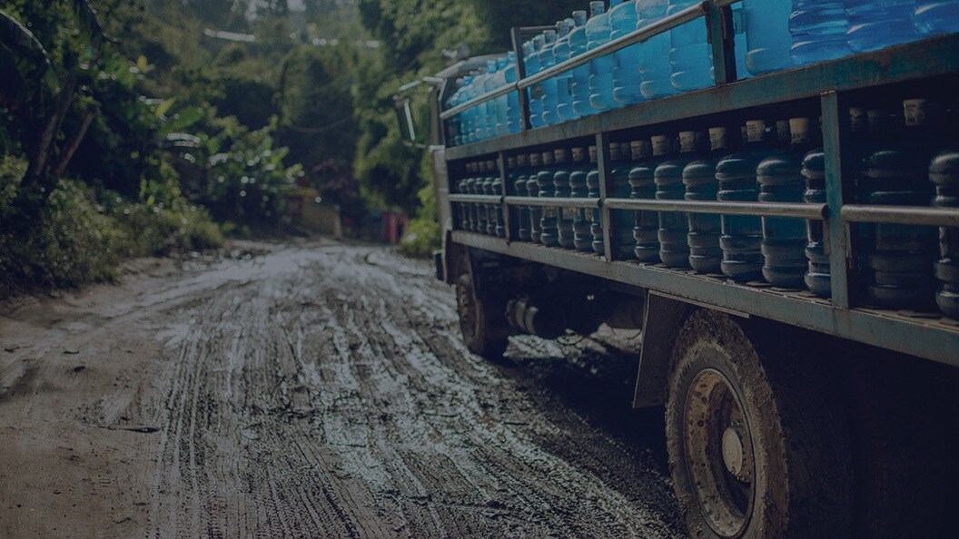 Quick-response logistics - A truck carrying relief supplies like water cans in a difficult terrain.