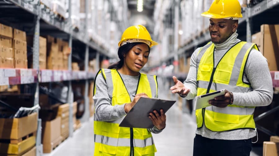 Man and women discussing in supply chain warehouse