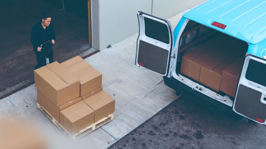 A man loading the cargo in a blue colored van