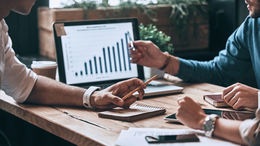 A group of people analyzing data on the laptop