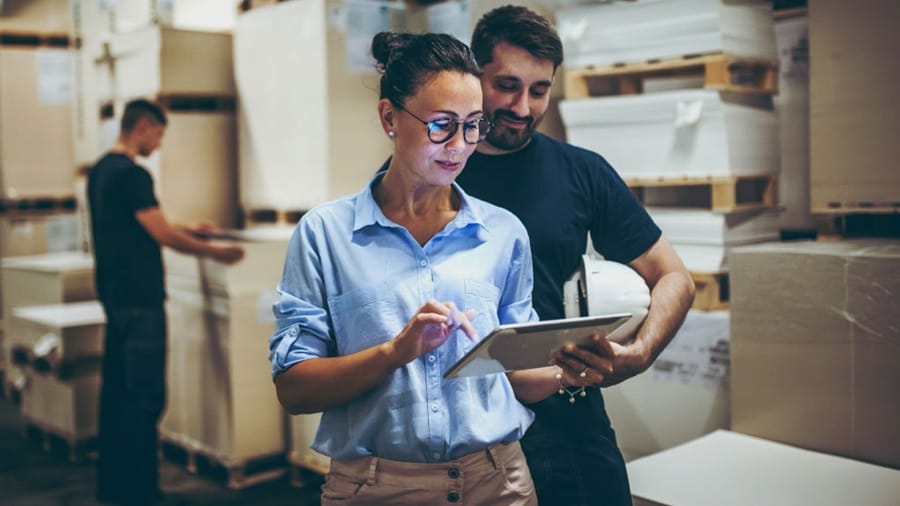Male looking over a female reading from her tablet