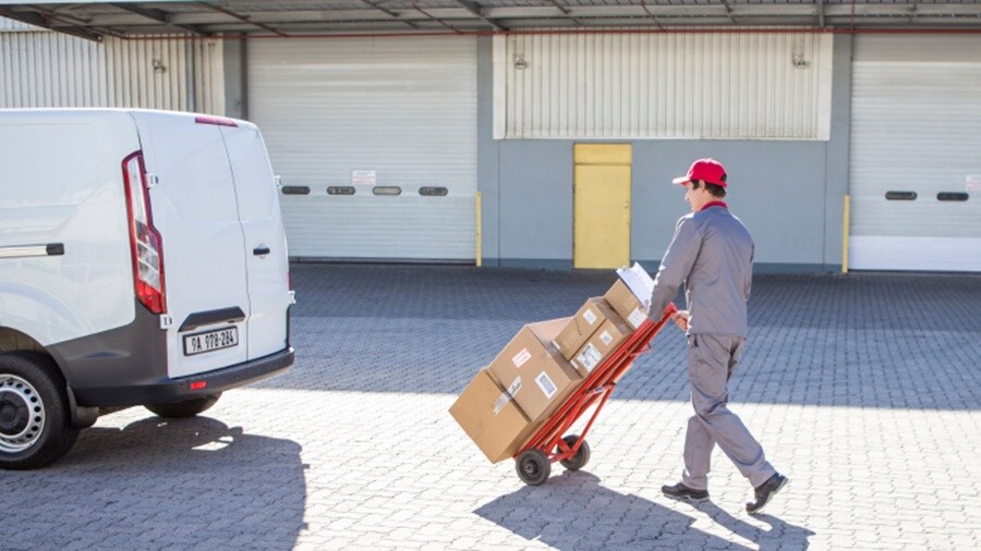 Male loading shipments to a truck using a trolley