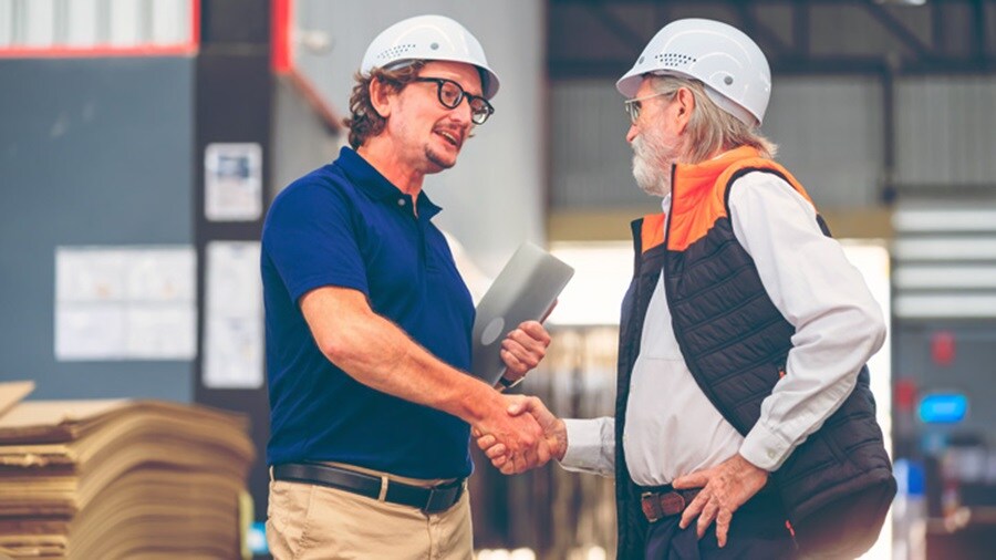 Two male shaking hands and conversing