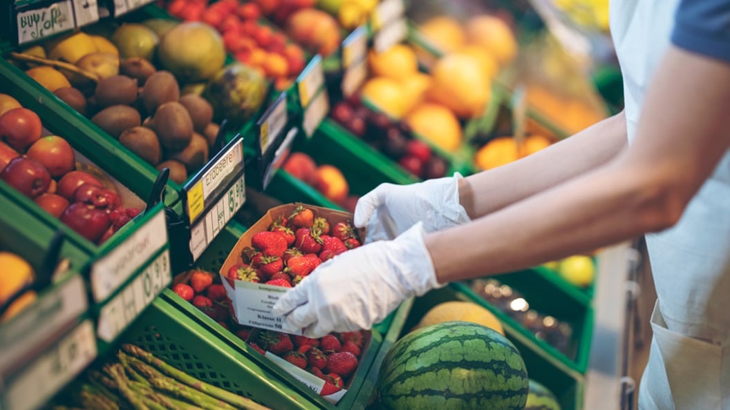 Close up of a set of hands holding fruits in a supermarket 
