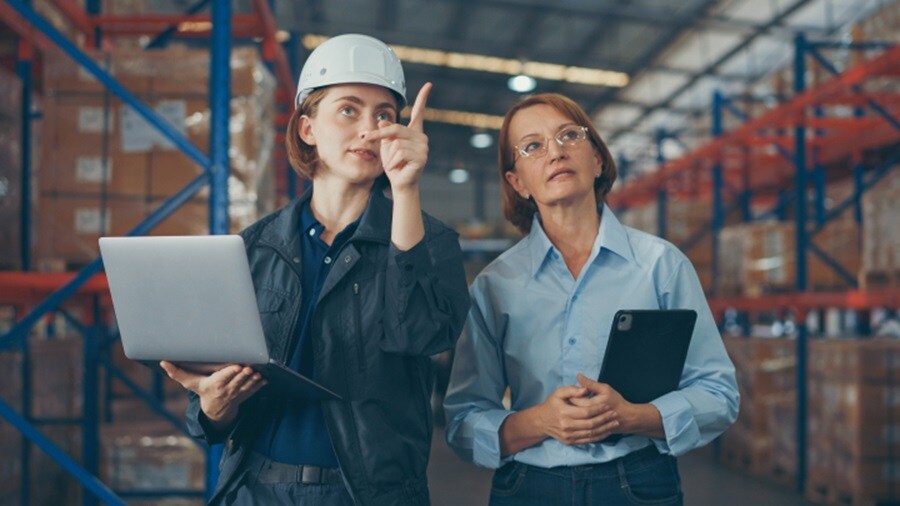 Two females having a conversation in a warehouse