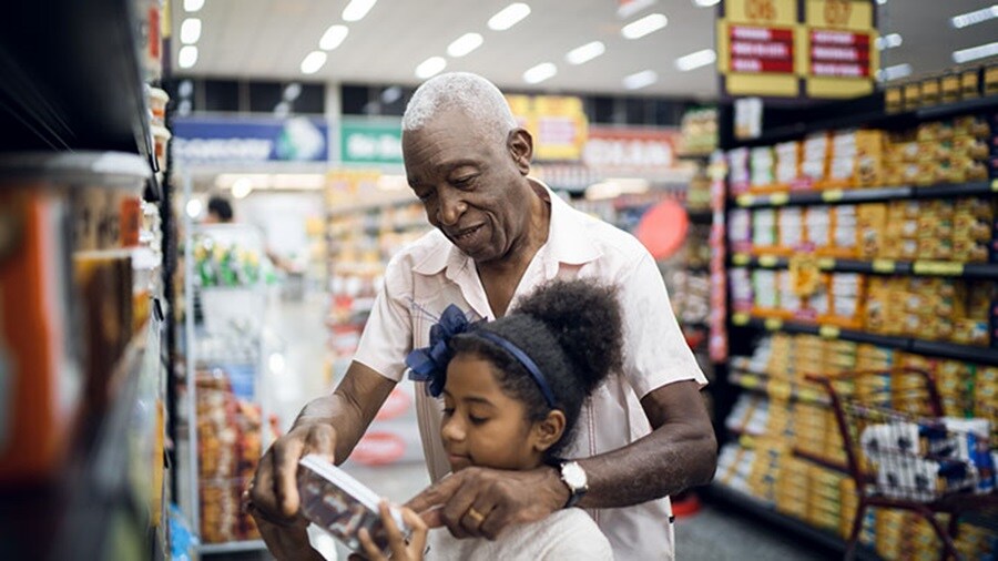 Grandfather and granddaughter purchasing items 