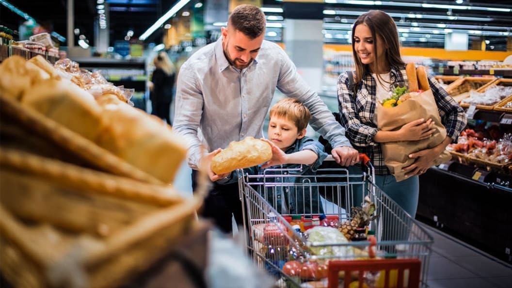 Happy young family shopping for groceries in supermarket