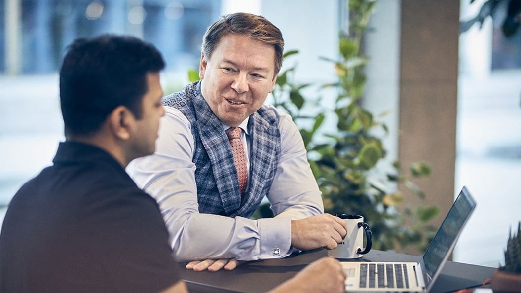 Two individuals with obscured faces packaging items in a warehouse.