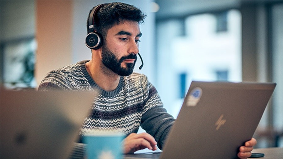 A person wearing headphones and using a computer