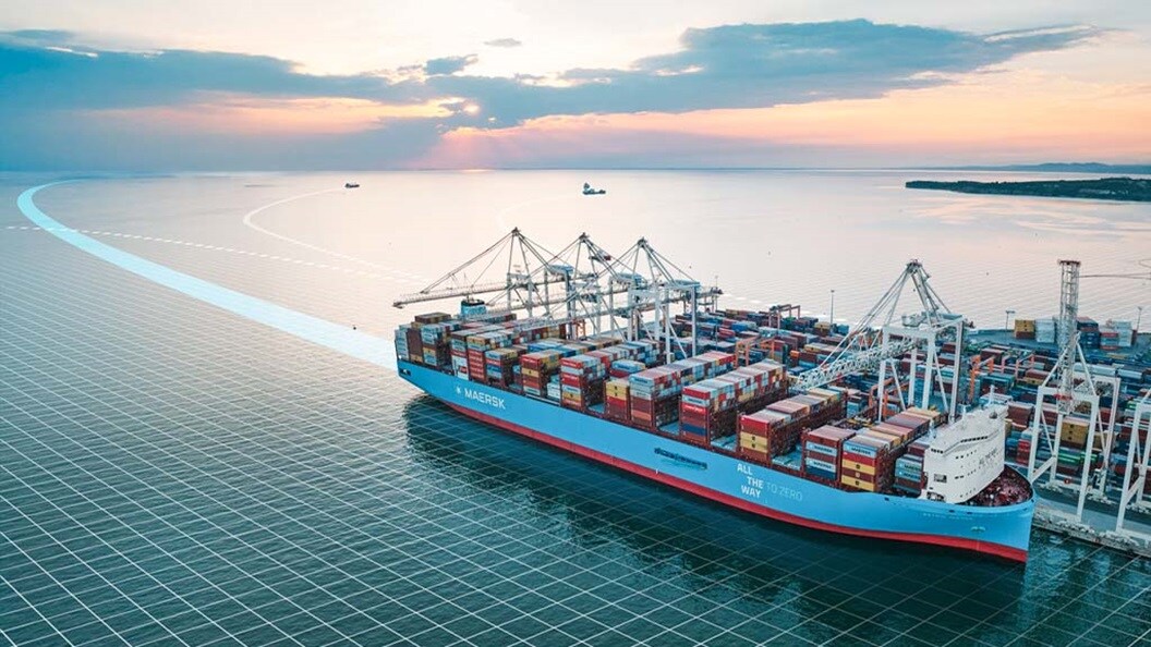 Large Maersk container ship docked at port during sunset.