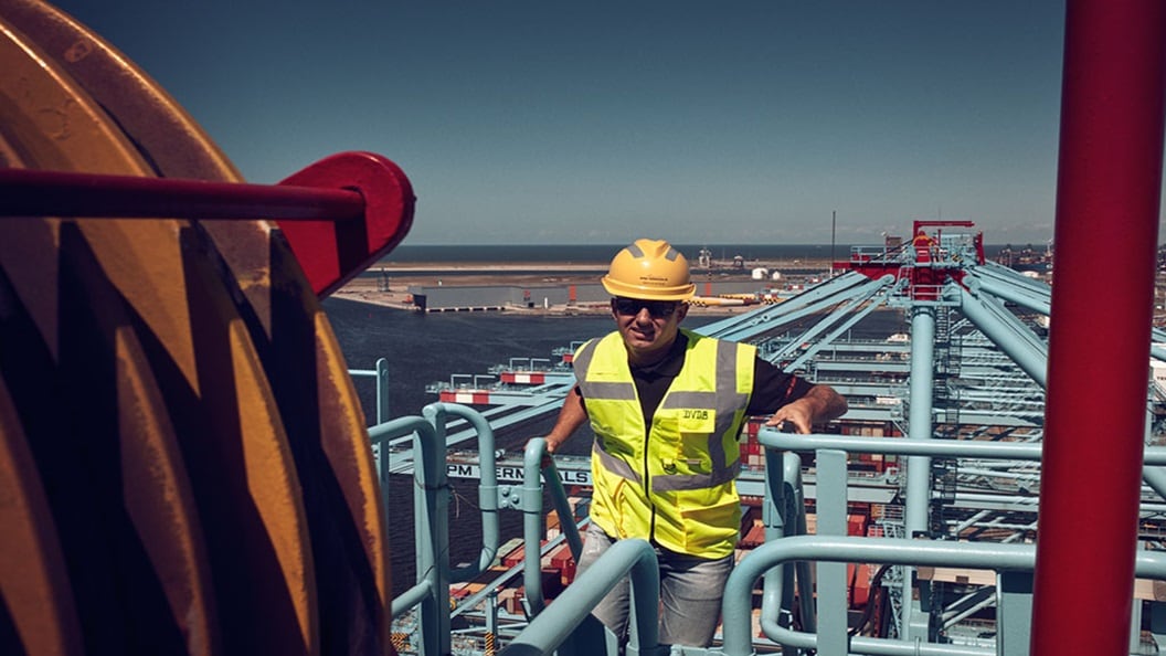 Crane operator standing on a crane with a view on the terminal.