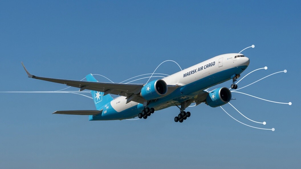 Maersk Air Cargo plane taking off under clear blue sky.
