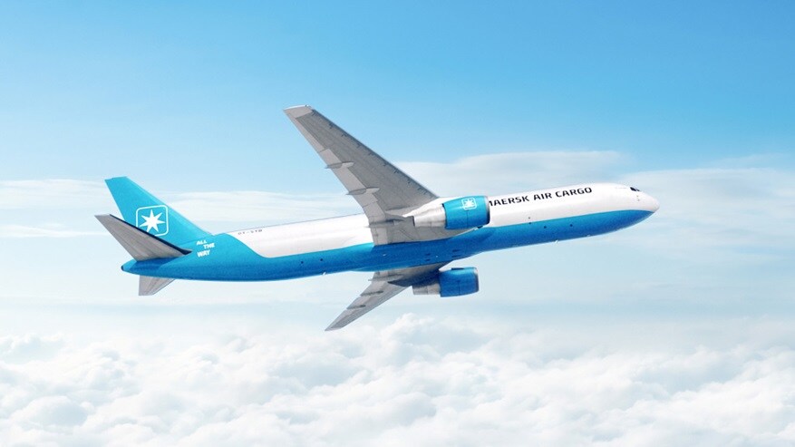 A blue and white airplane soaring through a clear blue sky.