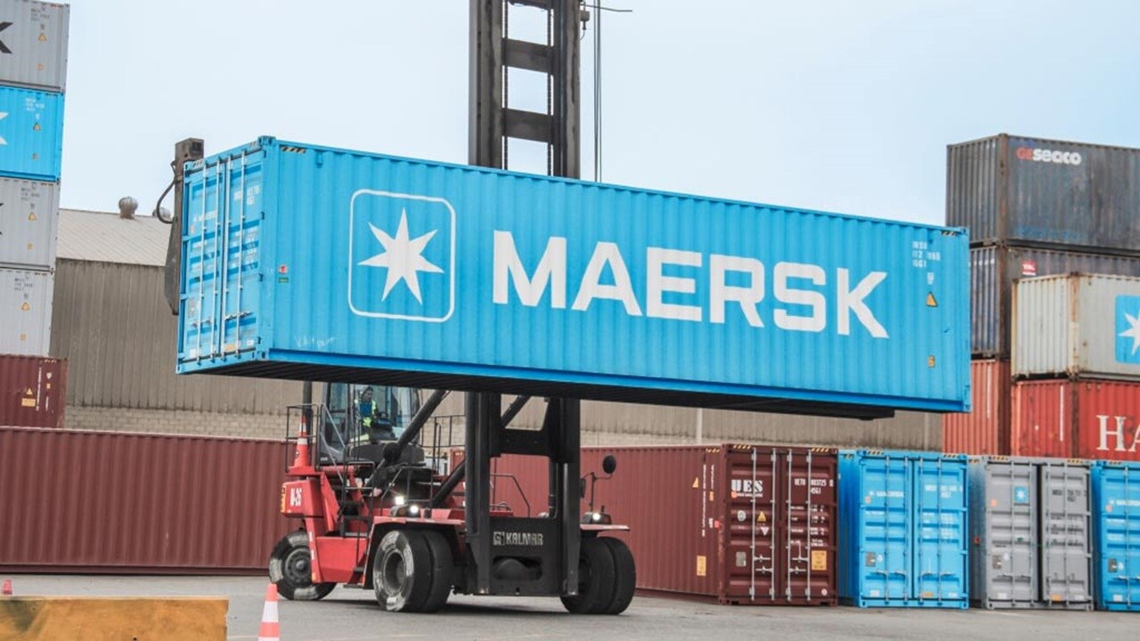 A forklift lifts a container labeled "maresk" at a shipping yard, showcasing industrial logistics in action.
