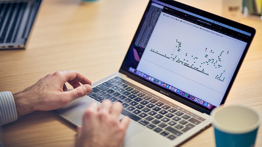 Person analyzing a data chart on a laptop screen.