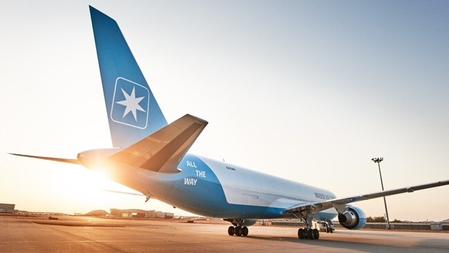 Maersk cargo plane on runway at sunset.