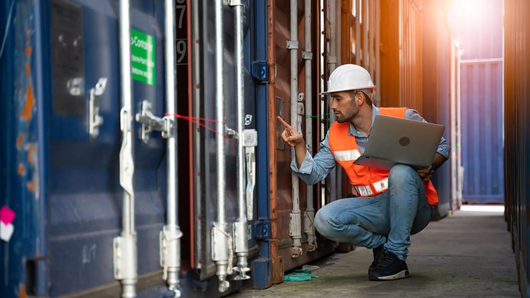 Employee with white hat and laptop in hand
