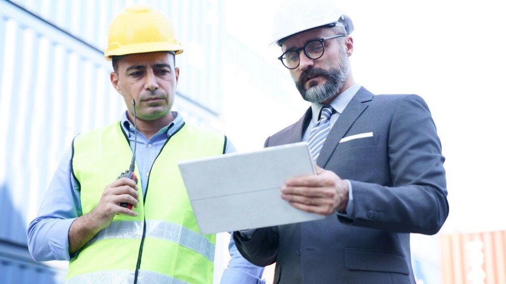 港口工作人员使用数字化设备协调货物详细信息