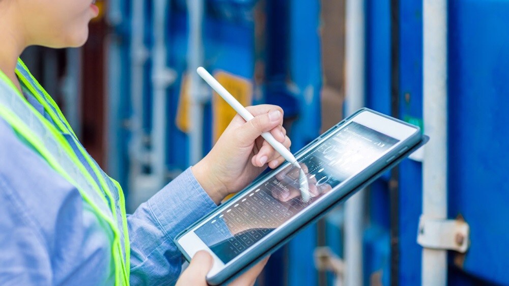 港口工作人员在平板电脑上监控订单信息