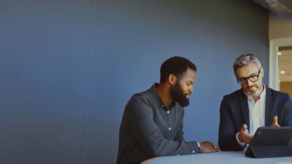 两位商人正在使用平板电脑讨论 ECTN 所需要的文档。