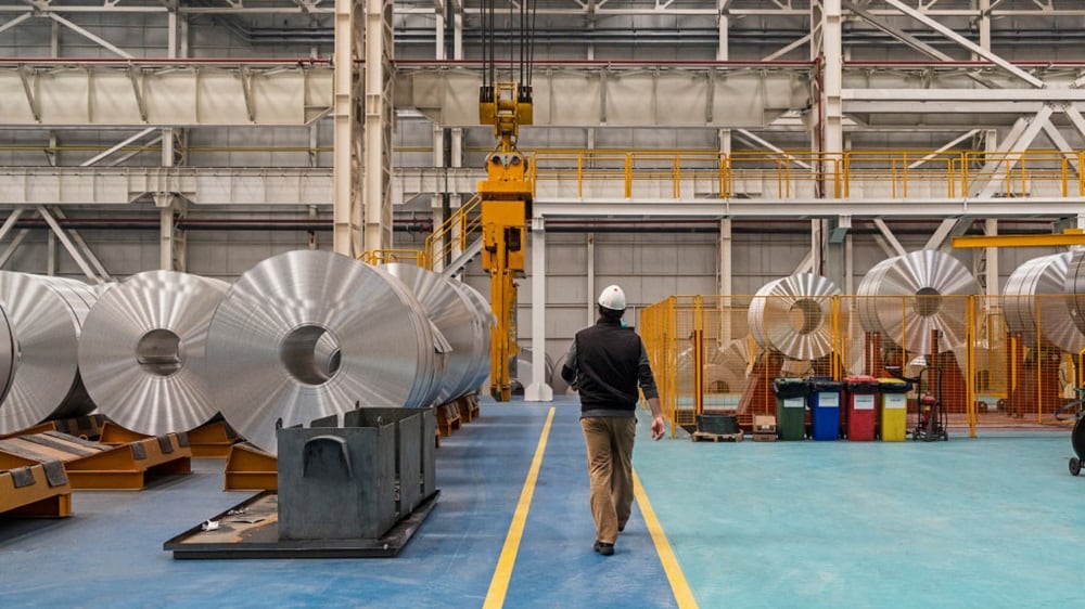 两名身着西装的商务人士握手，象征着协议或合作关系的达成，背景中还有第三个人。